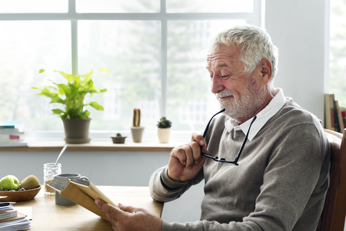 Older man smiling while reading