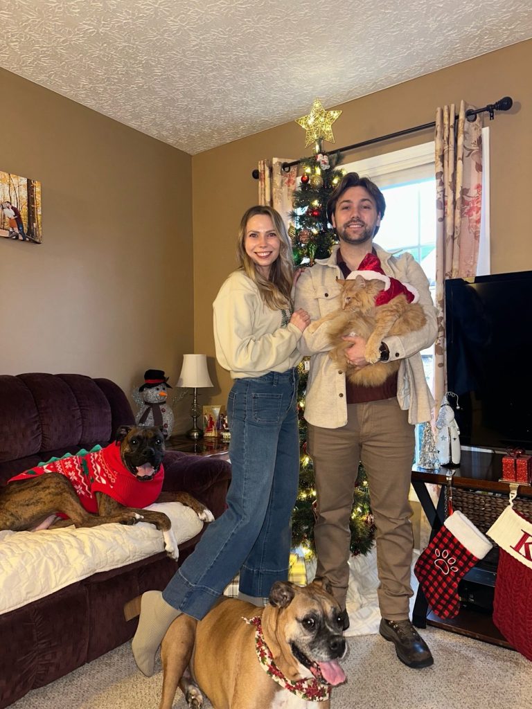 Dr. Maxwell and her family enjoying a Christmas morning together, with Kyra, Ares, and Kenai.